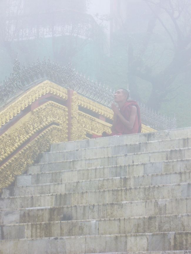 ゴールデンロックに向かって祈る僧侶。