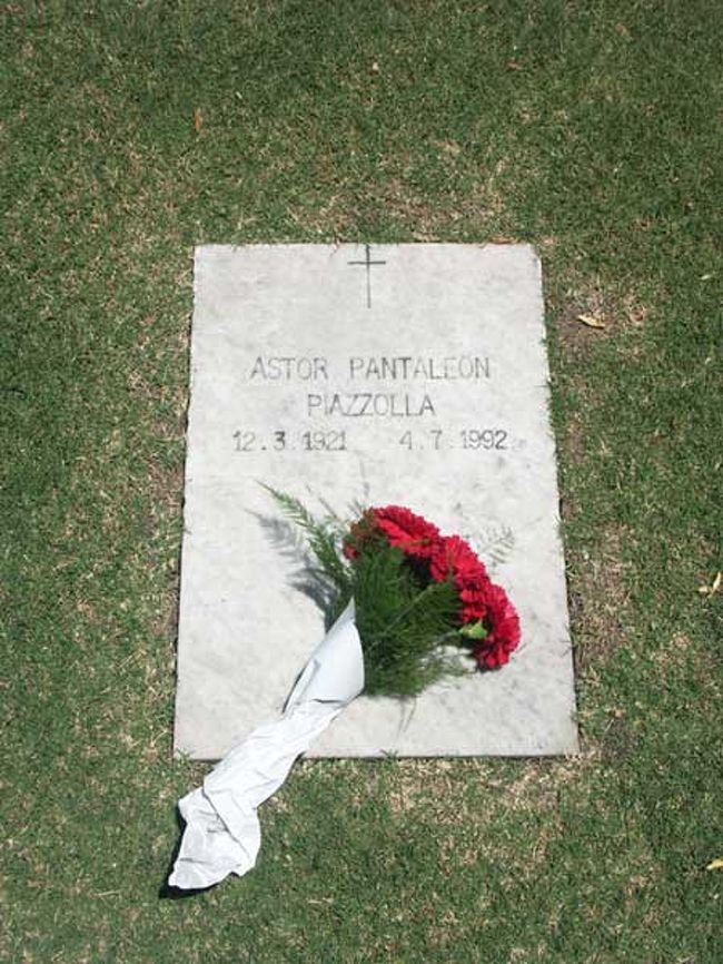 入り口の管理事務所で所在を尋ねた後、隣の花屋で供花を買った。私個人の勝手な思い込みで赤い花が似合う、と思い、カーネーションを買った。花屋を出て、番地をあてにうろうろしていると、管理人がゴルフカートに乗せてくれ、番地まで案内してくれた。それは、周りに沢山ある墓と同じ、5、60cmの白い大理石板に”ASTOR PANTALEON PIAZZOLLA 12.3.1921-4.7.1992”とだけ彫られたシンプルなものだった。