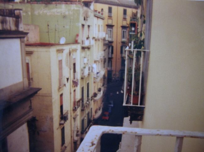View From The Hotel,Naples<br /><br />ナポリ(Naples)に行くと言ったらLizが<br />「私も行きたい！一人じゃ怖いから一緒に行く！」<br />というので突然決まったふたり旅。<br />ナポリは治安が良くないので絶対一人では行けないけど、ナポリのワイルドな男も気になるらしい。<br /><br />可愛いな〜姉さん♪<br /><br /><br />ローマでさっそく電車に乗り遅れて次発を待つ。<br />やっぱり誰かと一緒に行動するって大変だ。<br />ナポリに着いてもLizは<br />「ホステルを探して歩きまわるのがしんどい」<br />と最寄のホテルに即決。ダブルベッドでふたり仲良く寝る。<br /><br />夫婦経営の可愛らしいホテルであたしもLizも満足。<br />こんな小さなホテルでもセキュリティーのおっちゃんが入り口に駐在、門限まで決められていた。<br /><br />ホテルに着くまでの短い道のりに見たもの。<br />酔っ払い　ホームレス　意味のない雄叫びをあげる若者<br /><br />どう見ても小学校低学年の子供達。<br />住宅地の狭い通りで原付バイクに3ケツして走り回る。<br />そしてすれ違う車に暴言を吐く。<br /><br />Liz姉さん：「ローマに帰りたい」<br /><br /><br />あたし個人的には結構気に入った。<br />決して清潔な町とは言えない。<br />Liz姉さんの言葉を借りると「汚なすぎる」<br /><br />だけど街並には味がある。<br />古くて汚れてて、アンティークのおもちゃ箱みたいな...<br />雑っぽいところが魅力的。<br />今まで見てきたイタリアの町は清潔で歴史があって素晴らしい。<br />ナポリには純粋に「かっこよさ」を感じた。<br /><br />ナポリの港から出ているフェリーでシチリア島にも行きたかったけど<br />今回は時間が足りない。<br /><br /><br />夜になって姉さんと町を歩いていると、車がいちいち停まっては声をかけてくる。<br />週末の夜、ナンパの車が起こす渋滞。<br /><br />ナポリに来て初めて姉さんの顔が輝いた瞬間です。<br /><br /><br />...しかし門限があったので夜歩きもほどほどに撤収。