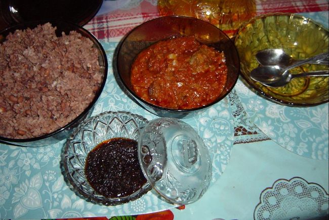 現地の家庭料理。<br />ワチェ（小豆のような豆を御飯と一緒に焚いた赤飯のような物）と真中はトマトベースのシチュー、<br />手前があみ海老を赤唐辛子と塩で味付けし<br />油で炒めたシトという調味料。