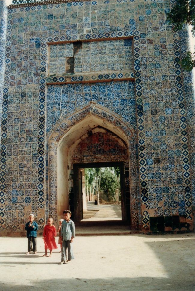 青いタイルが印象的な廟の入口。<br />観光客の後を付いて来た子供たち。