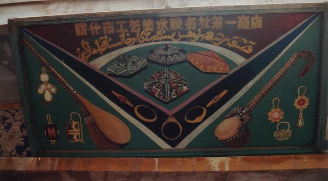 喀什商工芸美術服務社第一商店。中央にムスリム帽、左右に民族楽器、左にタンブール右にラワーブ、を配置した秀逸なデザイン。