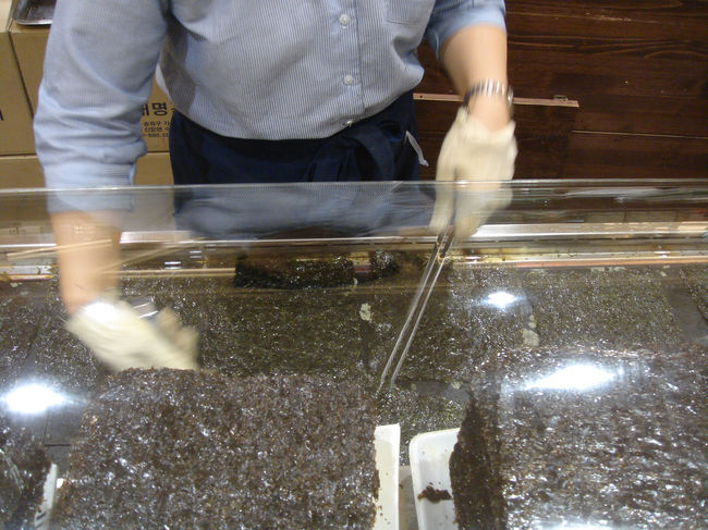 家土産としてド定番の韓国のりをデパートに買いに行きました。その場で石を使って焼いてくれています。<br />韓国のりとひとことで言ってものりの種類や味付けでいろいろあるらしく、試食しまくり。奥フケー。