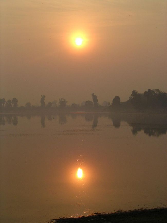 Srah Srangで朝日を望む<br /><br />到着した次の朝、昨夜契約したバイタクのにーちゃんと、<br />朝日を見に行く約束をした。<br /><br />朝起きると、とても暗かった。<br />そう、目覚ましが日本時間なのだ。<br />自分も、連れも、大急ぎで出かける準備をしたのに、<br />そのままもう一度爆睡。<br /><br />そして、待ち合わせの時間に起きた。<br />だが、バイタクのにーちゃんはこなかった。<br /><br />しかたなく、宿タプロムのバイタクのにーちゃんと<br />急遽契約し、朝日をみに向かったのです。