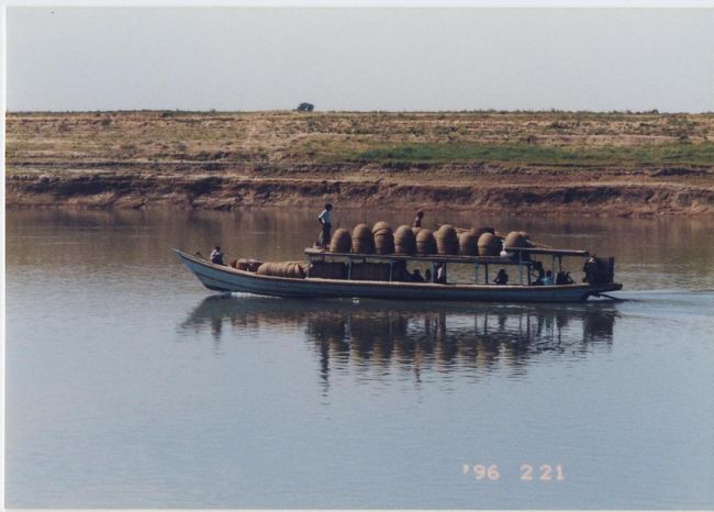 イラワジ川を行く小舟。<br />山盛りにつまれたのは竹かご。