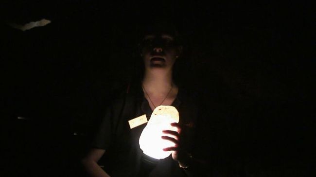 鍾乳石にライトをあて、光の拡散を見せてくれるガイドさん。