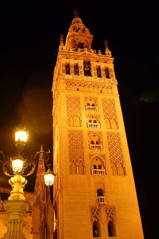 セビリヤのヒラルダの塔です。１２世紀末にイスラム教徒によって、一辺が１３．６メートル、<br />高さ７５メートルの塔が建てられました。<br />１６世紀に入り、キリスト教徒が現在の約９８メートルの塔に、改装・増築しました。<br />また塔頂には、風見(風向計）として、信仰を象徴する女性像が取り付けられています。<br />ライトアップされていて、幻想的でした