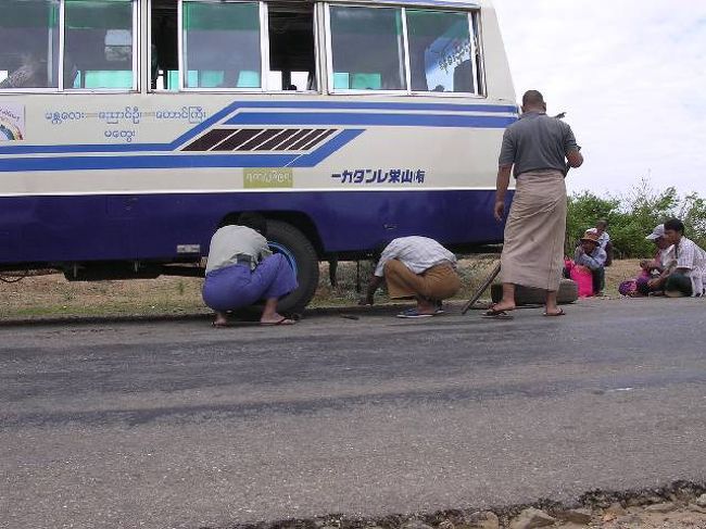 バスは途中でパンク<br />パイプでジャッキアップ。乗客も手伝います