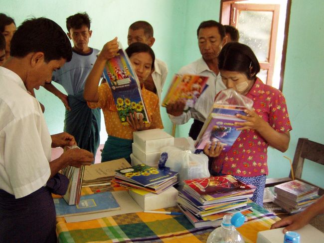 　学校に着くと、既に生徒たちが運動場に整列していた。学校に行っても、生徒たちが集まるまでばたばたしたりするんだろうと思っていたが、全くの杞憂だった。ウィンウィンの段取り、完璧じゃないか！　持つべきは良き秘書哉、である。<br />　職員室に荷物を持ち込み、ノートや鉛筆の束をばらした。今回各生徒に配布するのは、ノート２冊、鉛筆５本、青ボールペン１本。そして、カメラマン氏がウィンウィンに託していたハンドタオルと歯ブラシ。ハンドタオルと歯ブラシは合計で196あった。全校生徒数200名なので、今日受け取りに来られなかった生徒たちにはあきらめてもらうことにした。<br /><br />　右から、おばあちゃんの家にいた女の子、校長先生、そして先生たち。