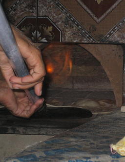 ロティを大きなショベルみたいなのに乗せて釜の中に入れます。