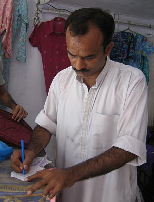 リリーの寸法をメモるおじさん。<br />土曜日にシンガポールに一時帰国するので金曜日の夜までに仕上げてもらうことになりました。<br /><br />「三日で仕上げろってか？ほかにも立て込んでるからなあ。」<br />といいながらシブシブＯＫしてくれました。<br />ブラウス1枚の仕立料500円です。