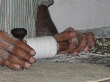 ローラーで伸したあと、右手にもっている剣山のようなスタンプで<br />ロティに無数の穴をあけます。<br />そうすると上と下の皮がくっつくので焼いても真ん中がブワンとふくらまない。<br />穴から熱い空気も逃げるしね。<br />