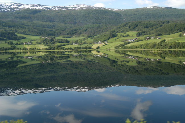 鏡のような湖面に映る山。ベルゲンからヴォスへの走行中のバスより<br />