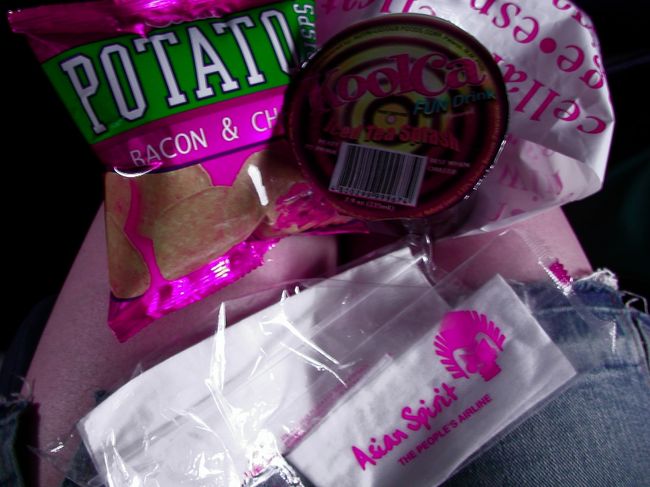 画像は悪いですが・・・<br /><br />短いフライトの間には<br />スナック菓子と飲み物が配られました。<br />テーブルも無かったので、足の上に置いて。