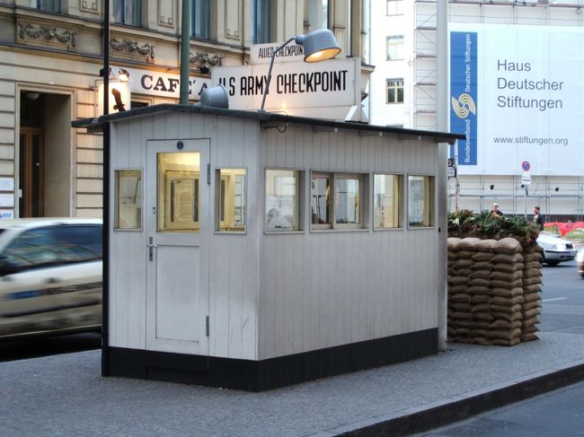 既に相当歩いていますが、見れるものは見ておこうと、22:00まで営業している、チェックポイント・チャ−リーへ向かいます。<br /><br />ここはベルリンの壁があった時代,国境を越えれた検問所のうちのひとつ。<br />地下鉄の駅を出ると、道路の真ん中に写真の検問所が建っています。壁があったときにはもう少し北側にあったらしいですが。今や旅行者が道路の真ん中を頻繁に行き来するので別の意味で危ないです。。