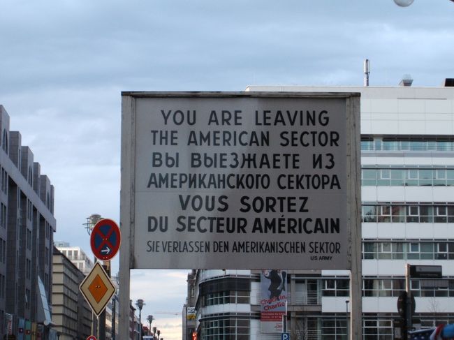 「あなたはアメリカの支配地域を出ようとしています。」<br /><br />ベルリンはあくまでもドイツ領ではなかったので、ドイツ語が一番下になってしまうんですね・・・。<br /><br />ここにも博物館があり、壁越えを図った人たちの歴史が綴られています。自動車のトランクやエンジンルーム、運転席の下、トンネル、熱気球とありとあらゆる手段が使われていました。東側の人にとっては、まさに命がけの国境越え。越えてしまえば西側ではお咎めなし、という状態だったわけです。検問もそれに負けじと段々とボンネットの中なども丹念に調べるようになったとか。<br /><br />西側から東側へ、西のパスポートを持つ人が移動する場合はゆるかったようですが。