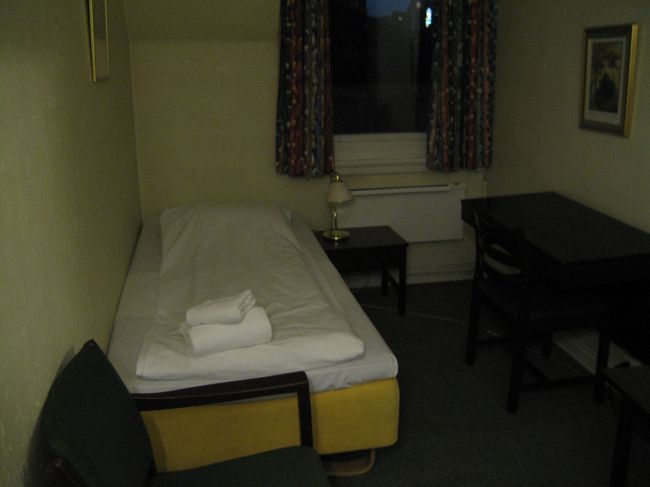 オスロ駅周辺は週末のせいか酔っ払いが非常に多く、注意してスーツケースを転がした。<br />とにかくホテルへ急ごう！<br /><br />ホテル「シティ」。ここで2泊しました。<br />ガイドブックの情報通り、駅から2,3分でした♪<br />さて、入ろうとするが自動ドアがあかない！！<br />ピンチ！時間が遅すぎたか？！<br />チャイムがあるのを発見！2回ほど押すと少し間をおいて、Hello！という女性の声。<br />しどろもどろに身分を説明した。<br />やがてドアが開き、フロントは４Ｆと知っていたので、エレベーターへ！<br />４Ｆには声の持ち主が迎えてくれた。<br />さっそくバウチャーを見せ、部屋の鍵をもらう。<br /><br />ホテルの鍵は６Ｆだった。<br />部屋に入り、緊張がほぐれたとたん、<br />すさまじい疲労が襲ってきたｗ<br />無理もない、日本で朝起きてから、<br />実に２６時間が経過している。<br />そのまま寝ようかと思ったけど、シャワーを浴びる。その日の疲れは、その日のうちにね。<br />窓の外から、相変わらず酔っ払いたちの声が聞こえる。目覚まし時計をセットしてベッドに入るも、うるさいのと心の高ぶりで眠れない・・・。<br /><br />（２日目はオスロを離れたので、次の旅行記にゆずります。３日目へ！）