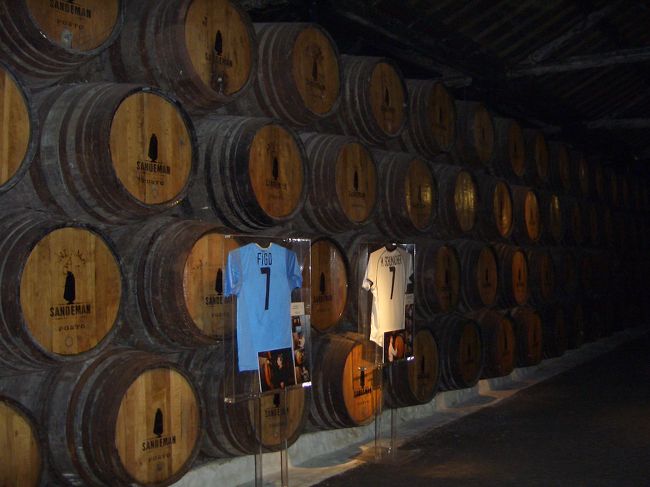 2006年6月27日14：40　さきほどの川岸にポートワイン工場の【SANDEMAN】を見学。タルのなかにワインがいっぱい！サッカーんおフィーゴ様も来たらしく、なぜかユニホームとサインが！<br />ワインの試飲もできました。私は赤のビンテージワインとサンデマンのワイングラスを購入。<br /><br />【SANDEMAN】<br />http://www.sandeman.com/new_packaging/sandeman_intro.html