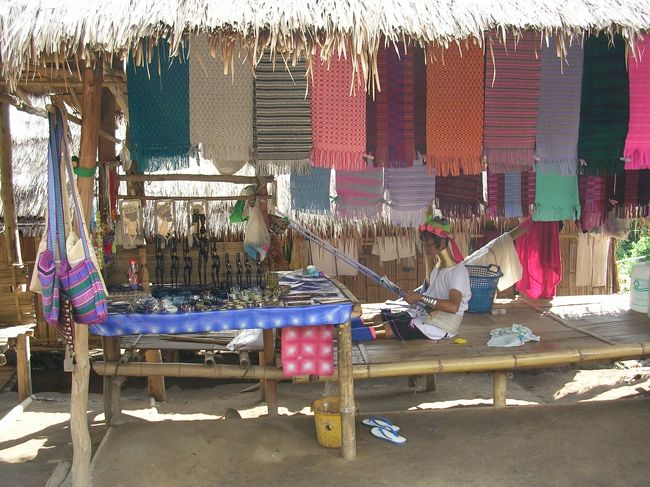 少数民族の人々４<br /><br />せっせと織物をしています。飾ってあるものは全て売り物です。