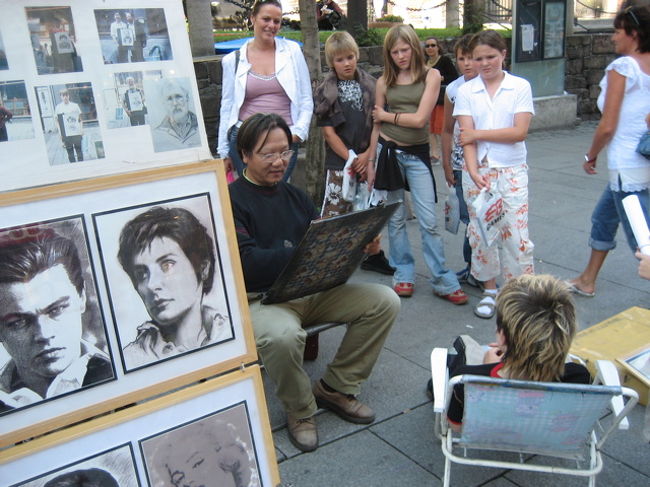 ギターを抱えて歌う人や似顔絵描きがいました。この男の子はものすごい出っ歯に描かれていましたよ。