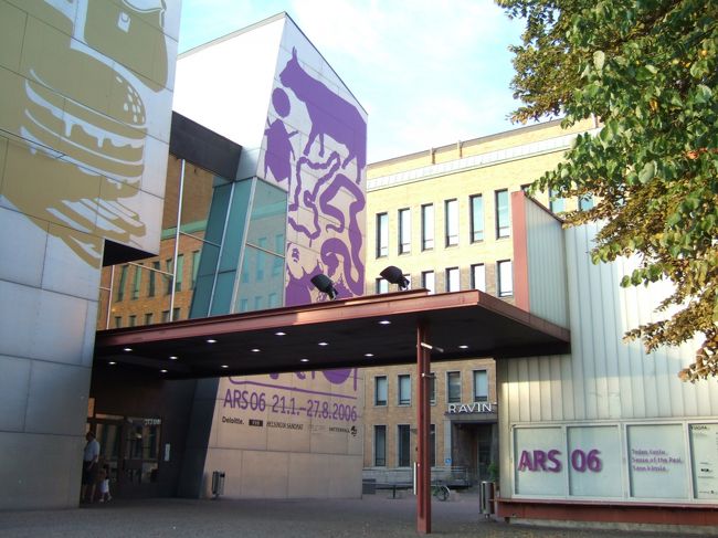 トラムに乗っているときに見つけた不思議な絵が描かれている建物が現代美術館「キアズマ」でした。<br />ヘルシンキ駅のそばの郵便局のそば。<br />この建物、開催中の展覧会にあわせて外壁の絵がかわるのですねーー。<br />いまは国際現代美術展「ＡＲＳ０６」にちなんだ絵。<br />仏像がいたり、ハンバーガーがあったり、、<br /><br />早速観覧。<br />日本でいまのってる作家さん「束芋」さんの映像をはじめ、アジアのアーティストの作品に面白いものが多かったように思います。<br />あとは内臓をえぐりだすような、人間の内側に迫るような・・<br />