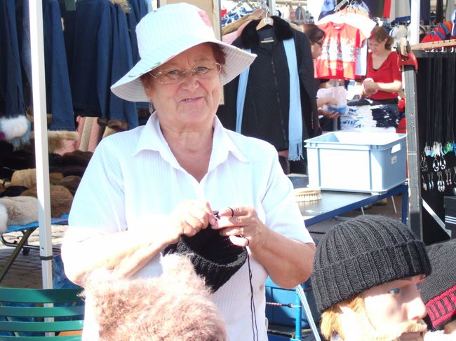 　この屋外マーケットはどちらかというと観光客向けのような感じでみやげ物がいっぱい。安いのか、高いのか。。<br />　私はトナカイの角で作ったという栓抜きを買いました。ちょっと古代人の壁画のモチーフのようなものが刻まれているところがツボ。<br /><br />　そのほかには毛皮だの毛糸でつくったものなど、早くも寒い冬を乗り切るための品物がたくさん。<br />　あったかそうなんだけど、この暑い夏に買う気にはなれず。<br /><br />　ただ、毛糸で編み編みしていたおばあちゃんがとてもかわいらしくて、連れの○ちゃんが帽子を購入。<br />　買ったついでに写真をとらせてもらいました。