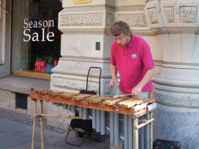 　マーケットからバルトの乙女像を見て、エスプラナーディ公園へ。<br />　昨日はトラムのとおる路線沿いしか見ていなかったので、このヘルシンキのメインストリートをとおるのははじめて。<br />　最終日、買い物に行くつもりのお店をチェックしながら歩いていると。。。<br />　どこからか素敵な音楽。<br />　へーー、朝からいい曲ながしてるなあと思ったら、なんと、生演奏！<br />　まだ人気の少ない街角で、おにいさんが一心不乱にマリンバをたたいています！！<br /><br />　すっごく上手！<br />　ちなみにこの場所、見るたびに違うアーティストが腕を振るっていました。弦楽器のおねーちゃん４人組や、アコーディオンじいさんとバイオリン女性のユニットなどなど。