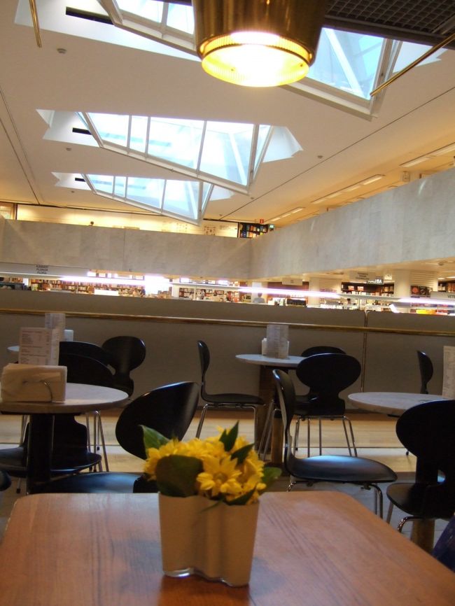 　私はポットコーヒーを注文（お変わりができる！）<br />　写真は隣の席から書店内の吹き抜けのほうに向かって撮ったもの。<br />　アアルトベースに花をいけています！<br />　二人でひとつ、チョコレートケーキを頼んだのですが、めちゃめちゃ甘かった。<br />　昨日食べたアイスもそうでしたが、甘いものはとことん甘い！