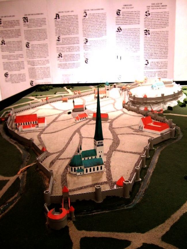 　ラエコヤ広場に面しているのはラエコヤ（旧市庁舎）、つまりタリンのタウンホールです。<br />　入り口に中世時代の格好をしたお兄ちゃんがいたので行ってみると、このタウンホールは見学できるらしい。<br />　<br />　入り口を入ると半地下になっています。<br />　お金を払って見学。この地下は、タリンの町の歴史の紹介展示になっていました。<br /><br />　エストニアからは緑色の良質の石が採取できるようで石の展示もあり。<br />　写真のような町のパノラマもありました。<br />　町が塀でぐるーーっと囲まれています。