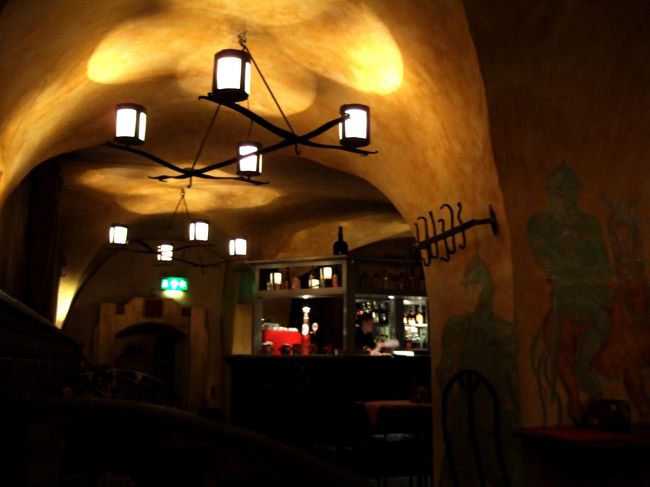 　広場から少し行ったところ、聖ニコラス教会の見える角にやっとインフォメーションがあり、地図をゲット！<br />　とりあえず一番奥にあるトーン城を目指すことにしました。<br />　その途中、お昼食べとく？ってはなしているときに教会の裏の道ぞいに見つけた怪しいレストラン。<br />　地下に降りていくと、洞窟？のようないい雰囲気。<br />　壁には中世騎士たちの絵が描かれ、座るところは武器を思わせる鉄製の重いイス。<br />　パンフレットによると店の名前は「Ｈ．Ｈ．Ｒｕｕｔｅｌ」というらしい。