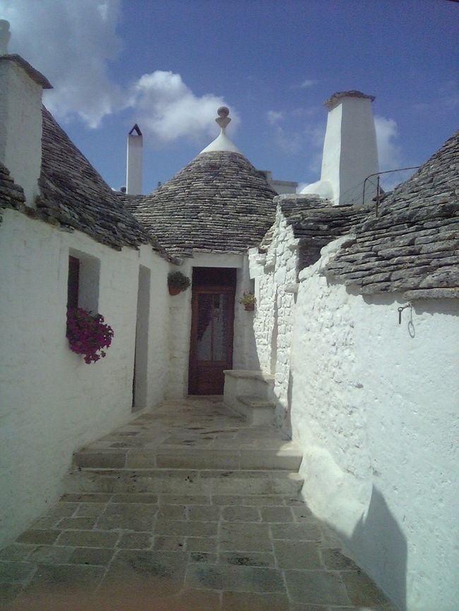 真っ白い壁＆円錐状の屋根。トゥルッリはとってもかわいらしく、青い空にとっても映えてる。土産やも多く、日本人観光客も多いのか、日本語で書かれた看板もちらほら。ん〜親切なんだろうけど、ないほうが風情があって良い気がする。
