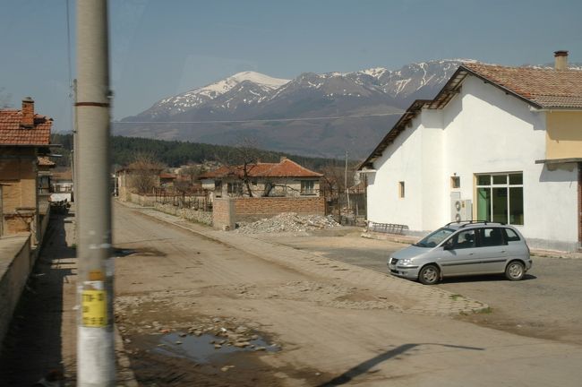 残雪のバルカン山脈の麓ののどかな農村風景です。