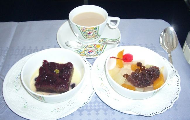 続いてやってきたのがデザートと食後の紅茶。デザートは左側が洋風コースのデザート、右側が和風。紅茶はミルクティーを頼むと、CAがちゃんとミルクティーを作って持ってきてくれた。砂糖が必要な人は、砂糖の数量も乗客から尋ね、ちゃんと砂糖入りの紅茶を作って持ってきてくれるのには感動した。他のエアーでもそうなのだろうか？<br /><br />