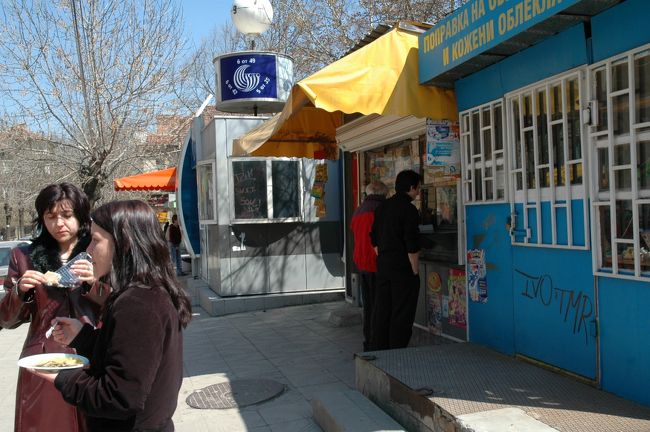 若い女性２人が昼食を立ち食いしています。