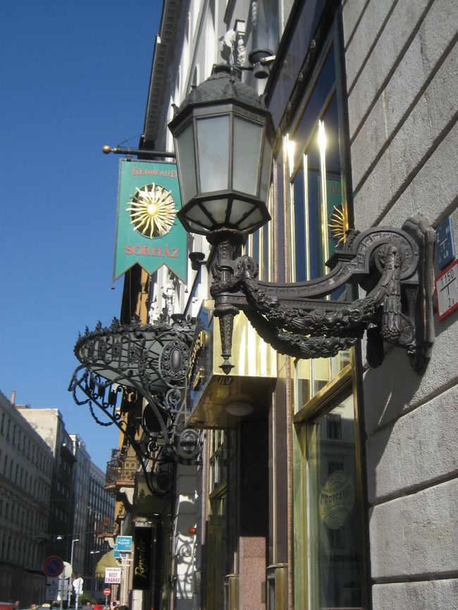 鉄道の予約をするために、旅行会社Calson Wagon社に向かいます。<br />この通りにあります。<br />うーん、この前時代的な古めいた街灯に、太陽の看板に、鉄細工の素敵な玄関。<br />欲張ってこれだけ全部を１つの写真に収めてしまいましょう。
