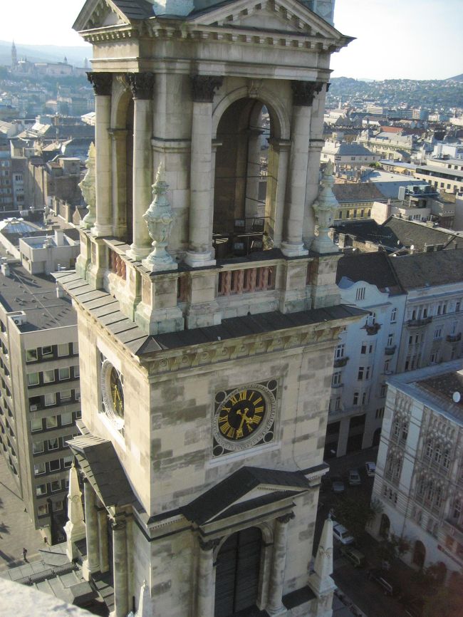 聖イシュトヴァーン大聖堂の塔から<br />手前に見える聖イシュトヴァーン大聖堂の塔を中心に<br /><br />塔に上ってみると、確かに一周ぐるりとブダペスト市内を見回すことができますが、写真の場合は逆光という問題があります。<br />午後遅くに塔に上ると、ぜひ写真を撮りたいドナウ川とブダ王宮は逆光になってしまい、写真が非常に撮りづらいことがわかりました。<br /><br />ちなみに、塔からの眺望に限らず、市内撮影のヒントとして、ペスト側から王宮側を撮りたいのであれば午前中、逆にブダ側から国会議事堂などペスト側を見下ろすのは午後の方が良いとあったのですが、この逆光の問題のせいと納得しました。