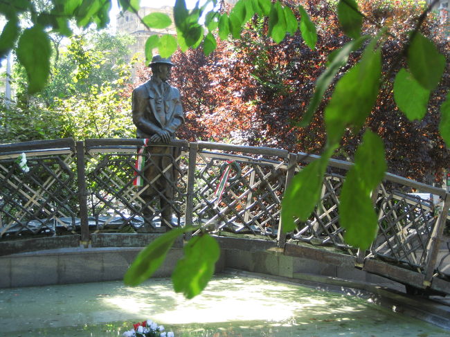 コッシュート・ラヨシュ広場のナジ・イムレ像<br /><br />国会議事堂のすぐ前がコシュート・ラヨシュ広場です。<br />2004年の初ブダペストから帰った後、「旅名人ブックス ハンガリー “千年王国”への旅」（日経BP社）をあらためて読んだ後、今度またブダペストに行くことがあったら、このナジ・イムレ像はきちんと見に行って、写真を撮ろうと思っていました。<br /><br />ナジ・イムレは1956年のハンガリー動乱の責任をとらされる形で処刑された当時の首相です。<br />ハンガリーで起きた革命をソ連が装甲車でけちらしに来たとき、ナジはきちんと国連の手続きを踏んで国際社会に救いを求めたのですが、大国の都合の前に小国が無視された痛ましい事件の犠牲者といわれています。<br /><br />2004年にブダペストを訪れたときにも、ハンガリー史をざっと勉強しましたが、このあたりについてはあんまりよく分かっていなかったので、今回の下調べのポイントとしました。<br />そうでなくても、ハンガリー関連本で歴史に触れている本ではほぼ必ずハンガリー動乱についての記載があります。<br />特に今回のハンガリー滞在ではこのハンガリー動乱の追悼日ではある10月23日が予定に入っているので、その背景をぜひ知りたいと思いました。<br /><br />余談ですが、私がここ最近、東欧旅行に魅了されている理由の１つは、私が学生のときには世界史として全く触れられることなく、いままでほとんど知らなかった東欧の歴史の奥深さもあります。<br />旅行に行こうと思えば、おのずと歴史に関心を寄せることになりますから。<br /><br />ハンガリー史に触れたのはチェコ史と同時なのであくまでその比較ですが、ハンガリーもチェコもハプスブルグやソ連に対する独立・民族自決を目指して革命を繰り返した歴史であるのに、チェコは革命が失敗しつつもその指導者たちはチェコでは往々にして最初からプラス評価されているのに、ハンガリーの場合、指導者たちの功績は次への運動のステップとなっているのに、指導者たち本人はみな悲惨な最期を迎えている、というのが印象的でした。<br /><br />ナジ・イムレもそんな末路をたどった典型的な指導者の一人でした。<br /><br />ナジ・イムレはソ連の手の届かないところに避難していたのに、だまされて身柄を拘束され、処刑されましたが、彼の処刑はその後のカーダール政権の確立のための陰謀とも、カーダール政策はナジの政策を引き継いだものだったともいわれているそうです。<br />処刑されたナジは、1989年の体制変換でハンガリー事件の見直しが行われた後、1989年６月に名誉回復と再埋葬式が行われました。<br /><br />ナジ・イムレ像はすぐに見つかりました。<br />顔が見える正面よりこのアングルが気に入ったのでこう撮りましたが、このアングルのせいか、ナジ・イムレは、国会議事堂に対し、ちょっとすねたようにそっぽ向いているように見えてしまいました@