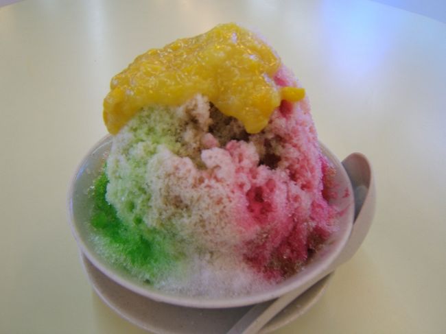 『アイスカチャン』という、マレーシアでは定番のデザート。<br />いわゆるカキ氷なんですが、氷の下に木の実や漢方薬の味がする黒いゼリー、数種類の豆や得体の知れないダンゴなんかが入っていて、いちばん上にはコーンを主体にしたソースがデロっとかかっています。食後にちょっと、って感じの量ではありませんでしたが、これで１００円程度です。