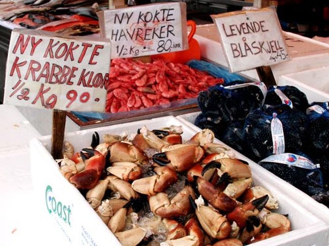 　港では魚市場が開かれています。サーモンや海老のサンドイッチも売られていて、みんな美味しそうに食べています。 