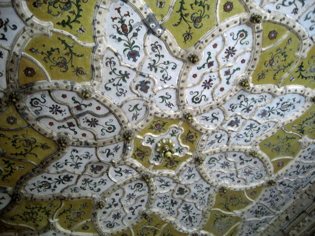 応用工芸美術館の入口の天井<br /><br />本当は入口の写真も撮りたかったのです。<br />とてもエキゾチック、というより、エキゾチックな要素を盛り込みすぎた、というかんじでしたが、それはそれでなかなか面白かったのです。<br />しかし、やはり暗くて写真写りがよくないのであきらめました。<br />でも天井は、露出をプラスにすることでなんとか撮れました。<br />草のつるや花をモチーフにした可愛らしい模様です。<br />アールヌーヴォーというより、やはりマジャール人のフォークアートというかんじです。洗練されているというより、オリエンタルであると同時に、どこか素朴で土のにおいを感じさせます。<br /><br />応用工芸美術館<br />「レヒネルの代表作。釣り鐘形のドーム、インド・イスラム風のアーチ、陶板で覆われたつる草のような形の手摺など、装飾はややくどい。しかし、ガラス張りの天井と吹抜けは、鉄筋コンクリート造の利点を生かしている。奇抜な外観と内装は物議をかもし、竣工後まもなく内装は入口周り以外白く塗り込められてしまった。」<br />（「建築・街並みガイド5」（エクスナレッジ社）より）