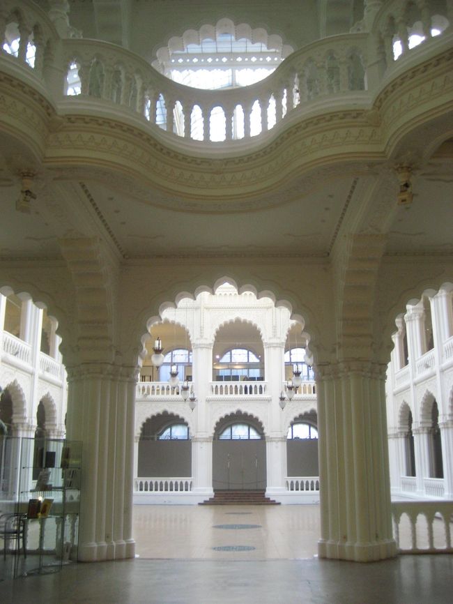 応用工芸美術館の中央ホール<br /><br />いよいよまちにまった応用工芸美術館の写真撮影。<br />これです、このイスラムチックな内部の写真を撮りたかったのです。<br />まるで宮殿のようです。うっとり。<br /><br />「19世紀末のウィーンやミュンヘン、パリでは既に新しい建築様式が生まれていた。それらはゼツェッシォン、ユーゲントシュティール、アールヌーヴォーなどと呼ばれ、柔らかな曲線を好んだ建物が地下鉄の駅や公共の建物に現われた。ブダペストでも傑出した建物が現われる。1845年生まれのレヒネル・エデンが建てた工芸美術館、地質学研究所、そして郵便貯金局である。このレヒネル三部作といわれる公共建築は、ドイツやオーストリアに見られる世紀末建築の流れとは異なり、純粋にハンガリー的であった。それが一目で分かるのは、ハンガリー南部の町ペーチュで生産されたセラミックを屋根や外壁に使用していることだ。（中略）このセラミックを使うことで、レヒネルはブダペストの世紀末建築にマジャル人の魂を吹き込んだ。内部では柱や手摺が波打ち、天井は揺らぐ。タイルを細かく貼った装飾はどこかオリエント風。ブダペストの世紀末建築はウィーンやパリのそれとは異なり、むしろバルセロナのガウディに近いと言われている。<br />　レヒネルの作品を見るには工芸美術館がお勧め。内には陶磁器や家具、織物などが展示されている。」<br />（「旅名人ブックス　ハンガリー “千年王国”への旅」（日経BP社）より）