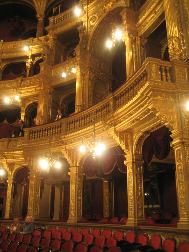 オペラ座の客席<br />ロイヤルボックスを中心に<br /><br />１番見やすい席であるだけてなく、VIPが座るのに相応しい風格があります。<br /><br />「オペラ座は、19世紀末のブダペストに多くの優れた作品を残した建築家イブル・ミクローシュが手がけ、９年の歳月をかけて1884年に完成した。パリやウィーンのオペラ座と比べると規模はいくぶん小さいが、内部の美しさはブダペストの方が優れていると判断する人が多い。実際、内部装飾は絢爛豪華で、そのこじんまりした外観も完璧に美しく、当初はヨーロッパ最高の舞台機構を誇っていた。客席はウィーンのオペラ座より200席ほど少ないが、奥行きのある舞台の規模は現在でもニューヨークのメトロポリタン劇場に次いで世界で２番目に大きい。」<br />（「旅名人ブックス　ハンガリー “千年王国”への旅」（日経BP社）より）<br /><br />「地球の歩き方」には「第２次世界大戦の戦禍を免れ」とありましたが、全く被害を受けなかったわけではなく、いまでも内部は修復中というのがオペラ座見学ツアーのガイドの説明でした。<br />また、「旅名人ブックス　ハンガリー “千年王国”への旅」には、「内部の美しさはブダペストの方が優れていると判断する人が多い」とありましたが、オペラ座見学ツアーのガイドは、その内部装飾の絢爛豪華さゆえに、修復にお金と時間がかかっていて、いまだ修復が完全に終わっていないとも話していました。