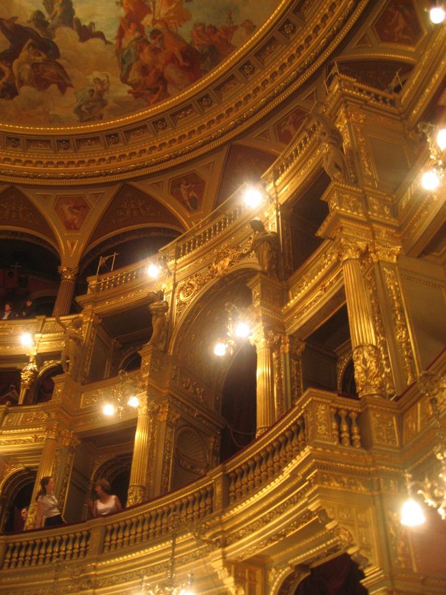 オペラ座のロイヤルボックスと丸天井の一部<br /><br />天井はシャンデリアの光が邪魔で、こうやって一部しか撮れませんでした。<br />天井画のタイトルは「オリンポス」で、画家はロッツ・カーロイです。<br /><br />「優雅なアンドラーシ通りに並ぶ建築で最も華やかなネオ・ルネサンス建築。歴史主義の退化イブル・ミクローシュの代表作で、ウィーンのオペラ座を意識しており、構成も似ている。流れるように上品な正面階段、彫刻で囲まれた客席天井、ギリシャ神話から題材を取ったフレスコ画など、贅沢な内装が施されている。」<br />（「建築・街並みガイド5」（エクスナレッジ社）より）