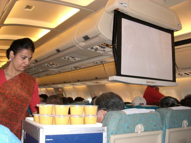 機内での離陸前ウェルカムドリンクです！<br />機内スクリーンは手動で下ろされ、<br />戻す時も、無理やり手で押し上げてました。<br />トイレも、暗くて中がよく見えないし・・・。<br />でも、またこのいい加減さとかが、<br />これから何が起こるのかワクワクさせます♪