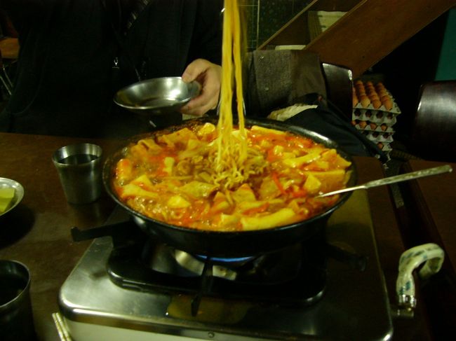 煮込んでいくとこんな感じになります。見た目はオレンジ色だった。思ったより薄い。店の主人曰く，日本人だから甘めにしたそうです。たしかに，周りの韓国人の鍋を見たら，真っ赤だった！私にはオレンジでも辛い！でも，おいしい。辛い時は，たくあんで舌を休ませて。