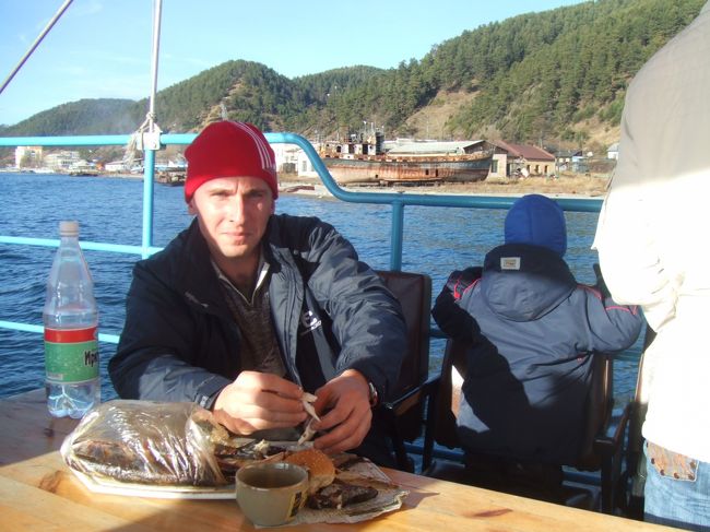 周遊フェリーに乗りました。３０分間ほど、１５０Ｐ＝約６００円。<br />バイカル湖でしか獲れない淡水魚･オムリが特産と聞いていたのですが、本当にみんなフェリーの上でも魚を食べていたのが面白くて「写真撮らせて」と言って撮らせてもらったのです。もちろん、魚を肴に飲んでいるのはウォッカなのですが。。。<br />