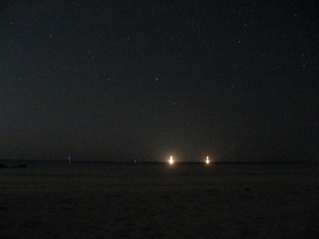 夜になるとビーチの明かりは、イカ釣り漁船の誘魚灯と…