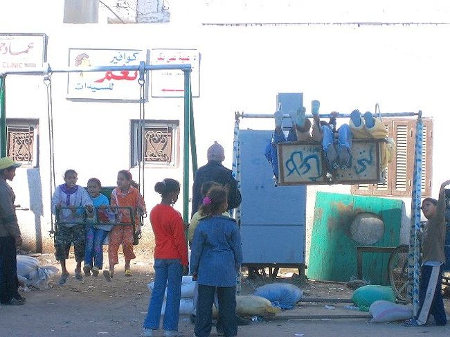 街中にポコンとあるブランコ。<br />高く揺れあがったブランコの裏にもアラビア文字。