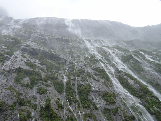 遊覧フェリーが氷河で削り取られた崖上の山の壁面に近づいてくれ、やっぱり下から見上げる壁面はスケールが大きすぎます。やはり、天気のいい日に見渡す限りこんな崖に囲まれた光景を見てみたくなっちゃいます。<br /><br />ただ、雨で爽快な風景ではない反面、逆に雨で無数の滝が絶壁の上から発生していて、これはこれで圧巻でした。