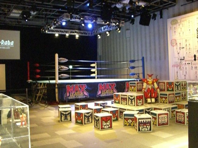 Kami-Robo Wrestling<br /><br />カミロボの展示会場。<br /><br />巨大なプロジェクターとプロレスのリングがあった。<br /><br />一見、プロレス同好会か何かのイベントに見えて近付き難い。<br /><br />ガラスケースには小さくて繊細な作りのカミロボ達が並んでいる。